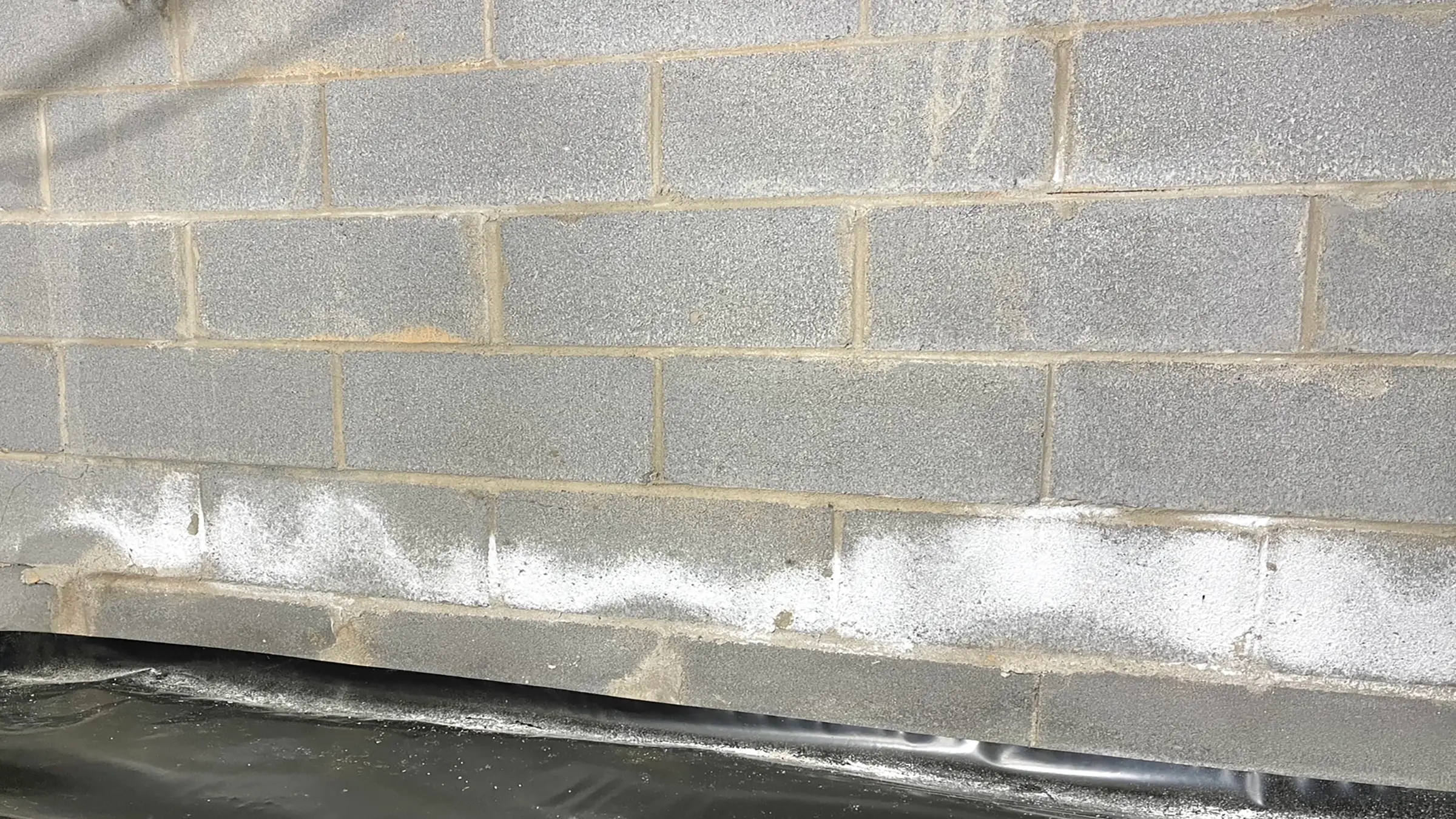 Cement block inside wall with efflorescence